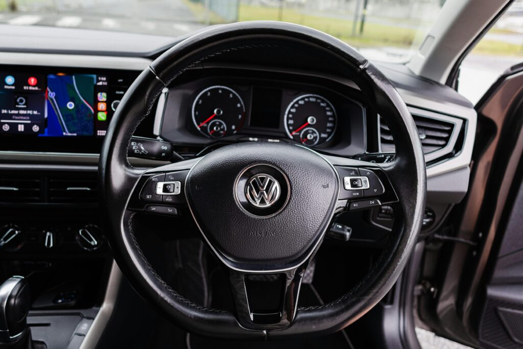 Close-up of Volkswagen car interior featuring steering wheel and dashboard.