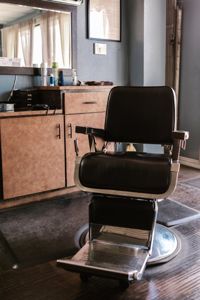 A vintage barber chair in a classic barbershop interior setting.